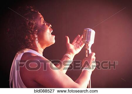 Stock Photo - Black woman singing on stage. Fotosearch