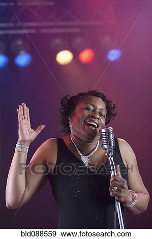 Stock Photo - Black woman singing on stage. Fotosearch