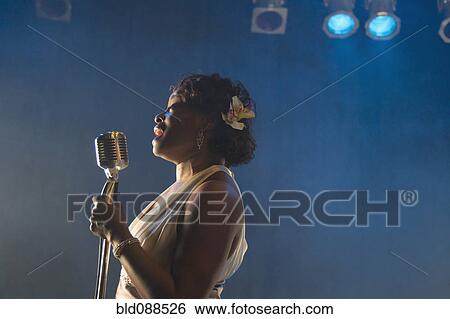 Stock Photograph - Black woman singing on stage. Fotosearch