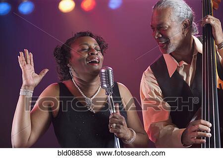 Stock Photo - Black woman singing on stage with jazz band. Fotosearch