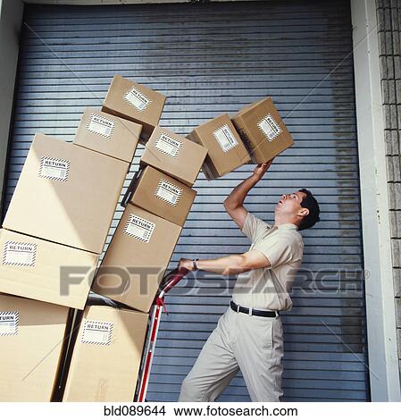 Boxes tipping on delivery man View Large Photo Image Picture - Boxes tipping on delivery man. Fotosearch