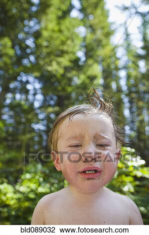 Stock Image - Boy crying outdoors. Fotosearch