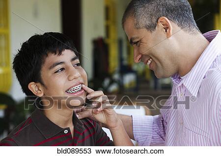 Boy showing father his braces View Large Photo Image Stock Image - Boy showing father his braces. Fotosearch