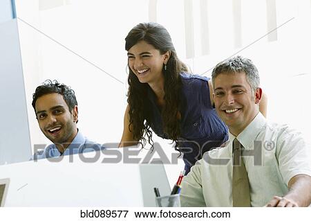 Stock Photo - Business people working together in office. Fotosearch