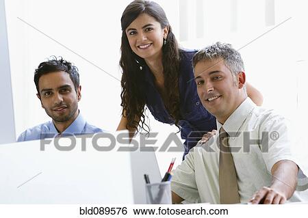 Stock Photograph - Business people working together in office. Fotosearch