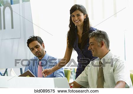 Stock Photography - Business people working together in office. Fotosearch