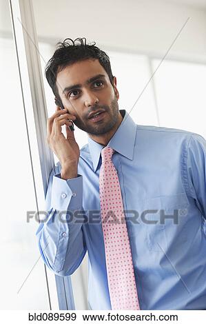 Stock Photo - Businessman talking on cell phone. Fotosearch