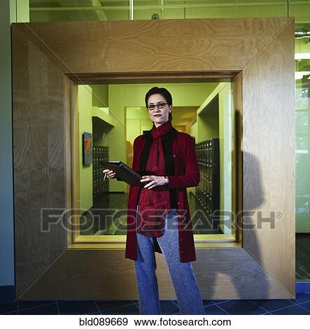 Stock Photo - Businesswoman with notebook standing in modern office. Fotosearch