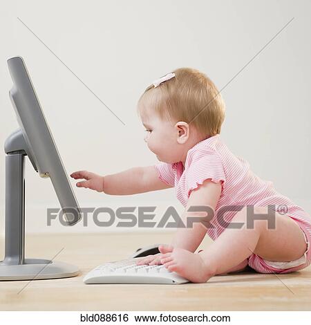 Stock Photograph - Caucasian baby playing with computer. Fotosearch
