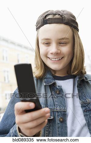 Caucasian boy text messaging on cell phone View Large Photo Image Stock Photography - Caucasian boy text messaging on cell phone. Fotosearch