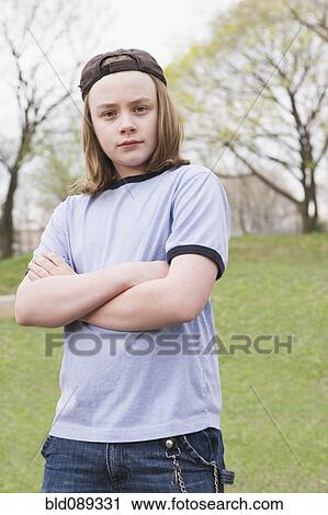 Stock Image - Caucasian boy with attitude standing in park. Fotosearch