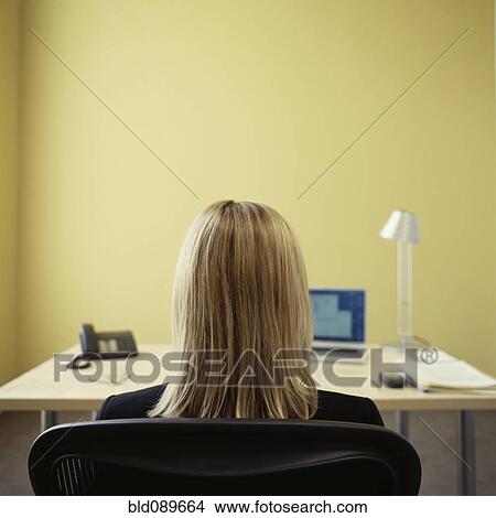 Picture - Caucasian businesswoman sitting at desk in office. Fotosearch