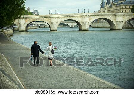 Caucasian couple holding hands and walking near river View Large Photo Image Stock Photography - Caucasian couple holding hands and walking near river. Fotosearch