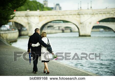 Caucasian couple hugging and walking near city river View Large Photo Image Stock Photo - Caucasian couple hugging and walking near city river. Fotosearch