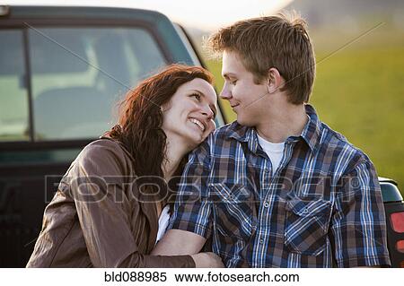 Stock Photography - Caucasian couple hugging in back of truck. Fotosearch