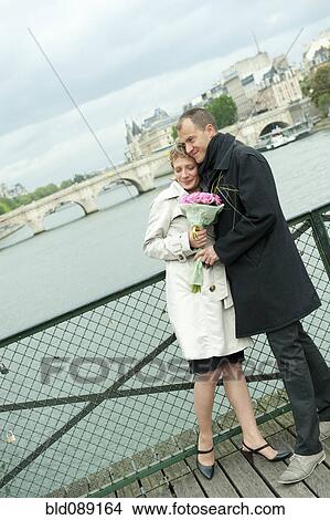 Picture - Caucasian couple hugging on bridge. Fotosearch