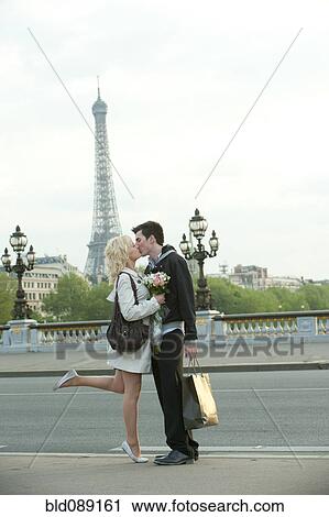 Caucasian couple kissing on bridge with Eiffel Tower in background View Large Photo Image Stock Image - Caucasian couple kissing on bridge with Eiffel Tower in background. Fotosearch