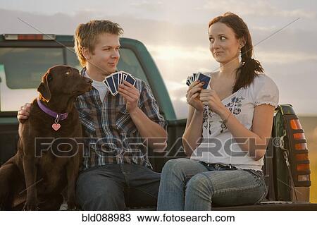 Stock Image - Caucasian couple playing cards in truck. Fotosearch