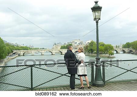 Caucasian couple talking on bridge View Large Photo Image Stock Image - Caucasian couple talking on bridge. Fotosearch