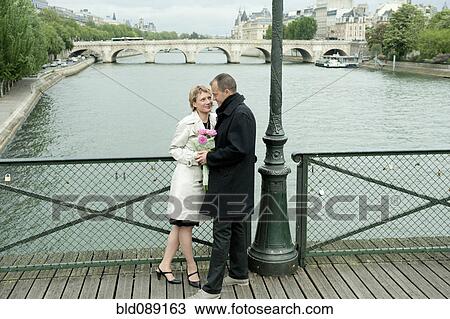 Caucasian couple talking on bridge View Large Photo Image Stock Image - Caucasian couple talking on bridge. Fotosearch