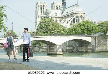 Caucasian couple walking along city river near Notre Dame View Large Photo Image Stock Image - Caucasian couple walking along city river near Notre Dame. Fotosearch