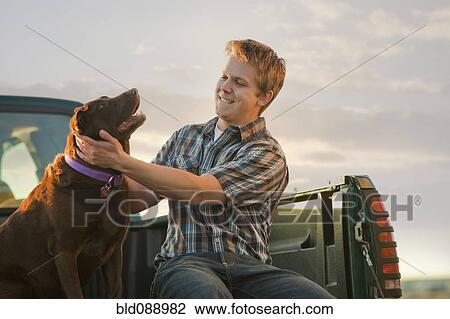 Caucasian man sitting in truck with dog View Large Photo Image Stock Image - Caucasian man sitting in truck with dog. Fotosearch