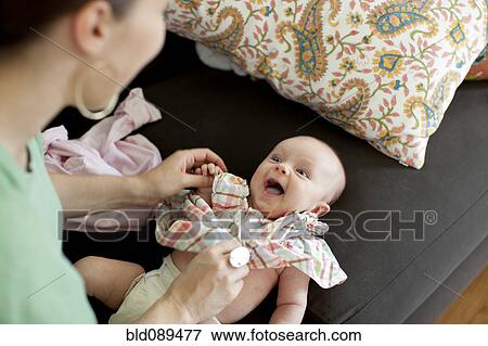 Caucasian mother changing baby daughter's clothes View Large Photo Image Stock Photo - Caucasian mother changing baby daughter's clothes. Fotosearch