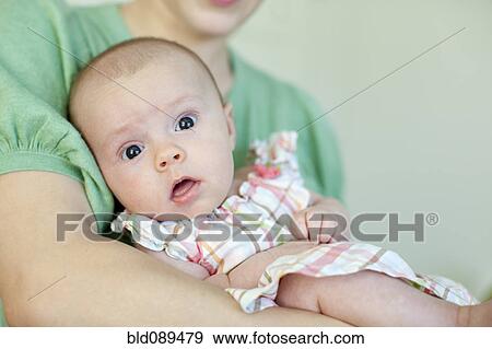 Stock Photo - Caucasian mother holding baby daughter. Fotosearch