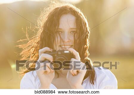 Picture - Caucasian woman taking photograph with camera. Fotosearch