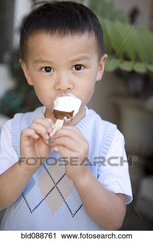 Stock Image - Chinese boy eating ice cream. Fotosearch