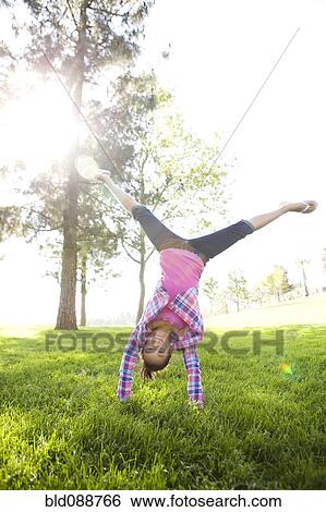 Chinese girl doing cartwheel in grass View Large Photo Image Stock Photograph - Chinese girl doing cartwheel in grass. Fotosearch