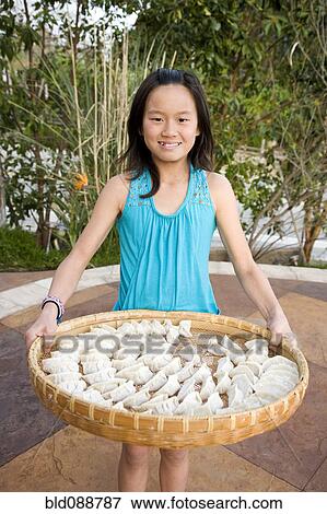 Stock Photo - Chinese girl holding basket of dumplings. Fotosearch