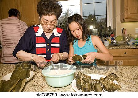 Chinese grandmother cooking with granddaughter View Large Photo Image Stock Photo - Chinese grandmother cooking with granddaughter. Fotosearch