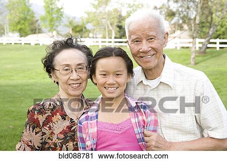 Chinese grandparents standing outdoors with granddaughter View Large Photo Image Stock Image - Chinese grandparents standing outdoors with granddaughter. Fotosearch