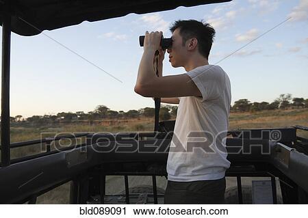 Chinese man riding in truck on safari using binoculars View Large Photo Image Stock Image - Chinese man riding in truck on safari using binoculars. Fotosearch