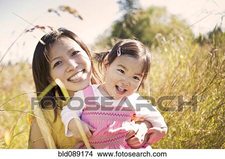 Picture - Chinese mother hugging daughter. Fotosearch