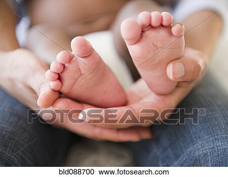 Close up of African American mother holding baby's feet View Large Photo Image Stock Image - Close up of African American mother holding baby's feet. Fotosearch