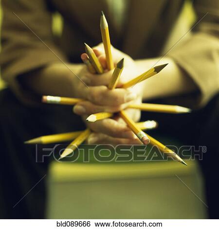 Stock Photograph - Close up of Caucasian businesswoman's hands holding pencils. Fotosearch