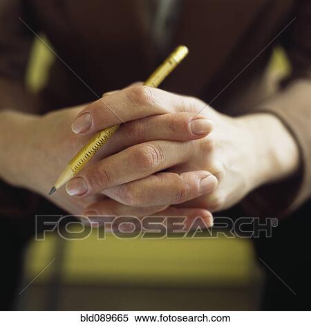 Stock Photography - Close up of Caucasian businesswoman's hands holding pencil. Fotosearch