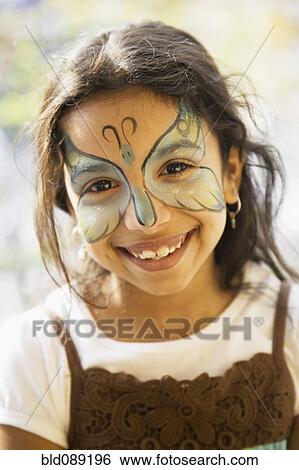 Stock Photograph - Close up of Hispanic girl with butterfly painted on face. Fotosearch