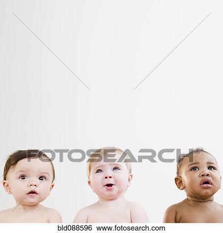 Stock Photograph - Curious babies sitting in a row. Fotosearch