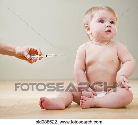 Stock Image - Doctor giving Caucasian baby injection. Fotosearch