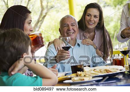 Stock Photo - Family enjoying meal together. Fotosearch
