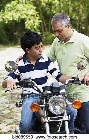 Father showing son motorcycle View Large Photo Image Stock Photo - Father showing son motorcycle. Fotosearch