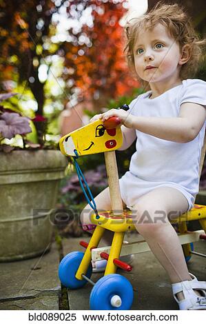 Girl riding wooden giraffe View Large Photo Image Stock Photography - Girl riding wooden giraffe. Fotosearch