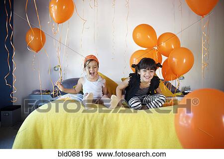 Girls sitting on bed together with balloons View Large Photo Image Stock Photography - Girls sitting on bed together with balloons. Fotosearch
