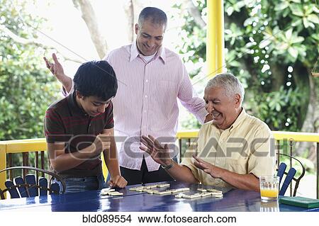 Grandfather, father and son playing dominoes on porch View Large Photo Image Picture - Grandfather, father and son playing dominoes on porch. Fotosearch