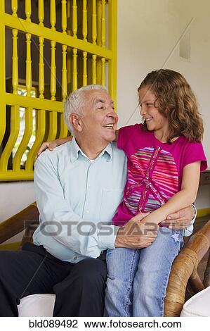 Stock Image - Grandfather sitting with granddaughter. Fotosearch