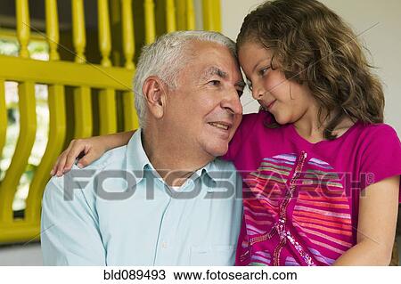 Grandfather sitting with granddaughter View Large Photo Image Stock Image - Grandfather sitting with granddaughter. Fotosearch