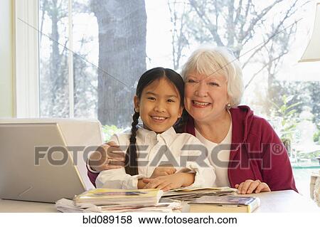 Grandmother hugging granddaughter View Large Photo Image Stock Photo - Grandmother hugging granddaughter. Fotosearch
